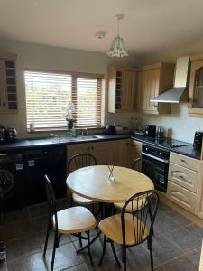 a kitchen with a wooden table and chairs and a sink at Apartment in milltown in Galway