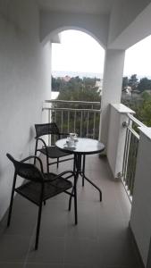 uma varanda com uma mesa e cadeiras. em Apartments Begonia em Starigrad-Paklenica