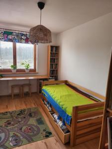 ein Schlafzimmer mit einem Bett mit einer grünen Decke in der Unterkunft Nature in Krakau