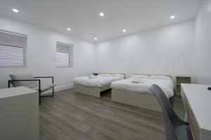 a white room with two beds and a chair at Charlotte Street Rooms by News Hotel in London