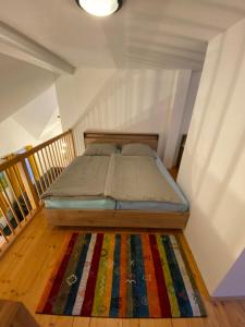 a bedroom with a bed with a colorful rug on the floor at Apartmán - Dovolená Mladé Buky in Mladé Buky