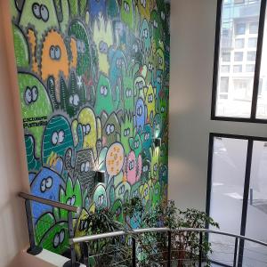 un mur orné d'une fresque colorée dans une chambre dans l'établissement Appart’hôtel Hevea, à Valence