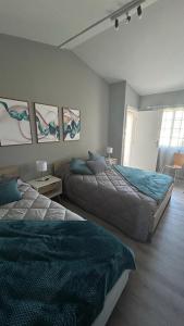 1 dormitorio con 2 camas y 2 mesas con lámparas en Hortênsia's AL, en Praia da Vitória