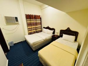 a hotel room with two beds and a window at Al Wehda Hotel in Dubai