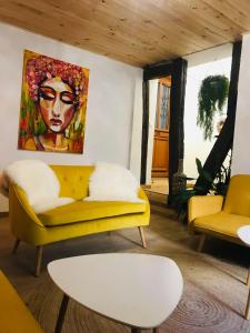 salon z żółtą kanapą i obrazem w obiekcie Hôte Labyrinthe sur la place chambres d, hôtes , calme ,Netflix w mieście Mirepoix