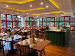 a restaurant with wooden tables and chairs and windows at Hotel Fioreze Origem in Gramado