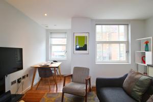 uma sala de estar com um sofá e uma mesa com cadeiras em Ibis House by Viridian Apartments em Richmond