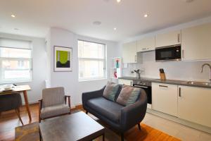 Ibis House by Viridian Apartments في ريتشموند: مطبخ وغرفة معيشة مع أريكة وطاولة