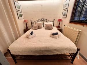 1 dormitorio con 1 cama con toallas en Vakantiechalet voor 4 plus 2 met sauna en Lanaken
