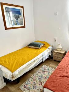 Un dormitorio con una cama y un cuadro en la pared. en Appartement vue sur golf Son Parc Menorca, en Son Parc