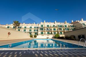 a hotel with a swimming pool in front of a building at Sea & Sunset by AcasaDasCasas in Ericeira