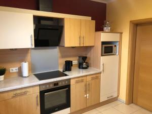 a kitchen with wooden cabinets and a white refrigerator at Ferienwohnung Hubertus in Irsch