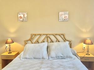 um quarto com uma cama com três fotografias na parede em Claudia em Roses