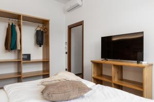 a bedroom with a flat screen tv and a bed at Terra Antica Apartments - La Fornace in Montepulciano