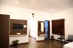 a room with a bed and a tv on a wall at GREEN MOUNT RESORTS in Malaiyāndipattanam