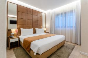 a bedroom with a large bed and a large window at Hotel Alvorada in Estoril