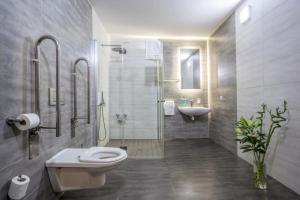 ein Bad mit einer Dusche, einem WC und einem Waschbecken in der Unterkunft Hotel Beta in Bzenec