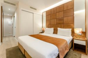 a bedroom with a large bed with a wooden headboard at Hotel Alvorada in Estoril