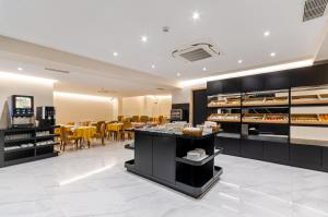 a restaurant with a bakery with tables and chairs at Hotel Alvorada in Estoril