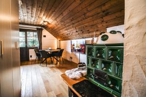 een woonkamer met een tafel en een groene kast bij MountainView Lodge - Am Fuße der Gondel und Skipiste in Sankt Oswald