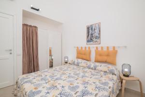 a bedroom with a bed with a blue and white comforter at Le Dimore Ibiscus in Stintino