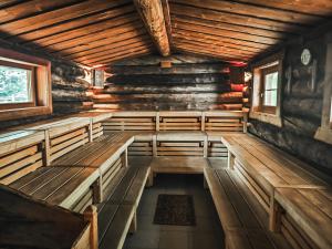 an empty room with wooden benches in a log cabin at MountainView Lodge - Am Fuße der Gondel und Skipiste in Sankt Oswald