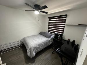 een slaapkamer met een bed en een plafondventilator bij Departamento en Torres Reyes ll in Tijuana