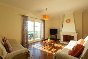 un salon avec deux canapés et une cheminée dans l'établissement Sea & Sunset by AcasaDasCasas, à Ericeira