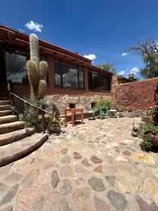a house with a cactus and a stone patio at Antigua Tilcara in Tilcara