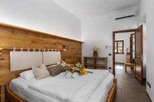 Un dormitorio con una gran cama blanca con flores. en Terra Antica Apartments - La Fornace en Montepulciano
