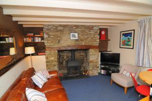 sala de estar con sofá y chimenea de piedra en 2 Castle Hall Llangrannog, en Llangranog