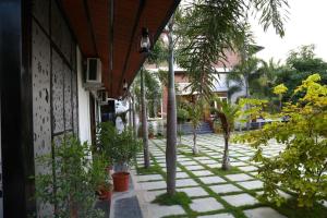 a courtyard with palm trees and a building at GREEN MOUNT RESORTS in Malaiyāndipattanam