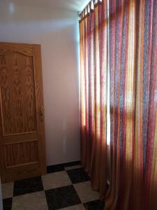 a room with a curtain and a wooden cabinet at Casa Benzambra in Cádiar