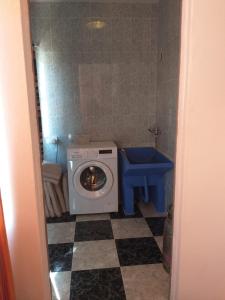 a bathroom with a washing machine and a toilet at Casa Benzambra in Cádiar