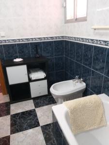 a bathroom with a sink and a toilet and a tub at Casa Benzambra in Cádiar