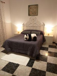 un dormitorio con un oso panda acostado en una cama en Casa Benzambra, en Cádiar