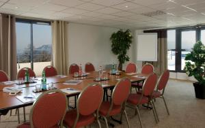 uma sala de conferências com uma mesa longa e cadeiras em Hôtel Le Palladior Voiron em Voiron