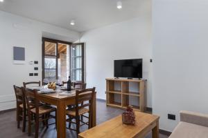 蒙特普齐亚诺Tuscany Living - Terra Antica的一间带桌椅和电视的餐厅