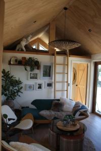 a living room with a blue couch and a wooden ceiling at Petite Perfection tiny house at Lake Hawea in Lake Hāwea