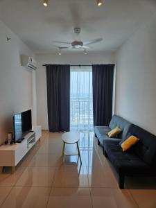a living room with a couch and a tv and a table at Metropol Serviced Apartment Bukit Mertajam Perda in Bukit Mertajam