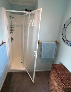 a shower with a glass door in a bathroom at Character on Capell large house perfect for extended family in Lake Hawea