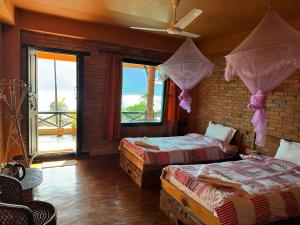 a bedroom with two beds with mosquito netting at Nar-Bis Hotel in Pokhara