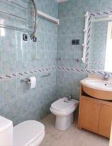 ein Badezimmer mit einem WC, einem Waschbecken und einem Spiegel in der Unterkunft Magnifico apartamento en primera linea de Playa in El Campello