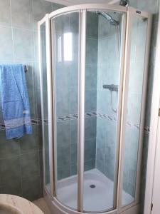 La salle de bains est pourvue d'une douche avec une porte en verre. dans l'établissement Magnifico apartamento en primera linea de Playa, à El Campello