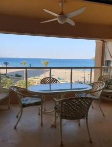 een tafel en stoelen met uitzicht op het strand bij Magnifico apartamento en primera linea de Playa in El Campello