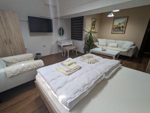 uma grande cama branca numa sala de estar com um sofá em Apartments Victory em Kavadarci