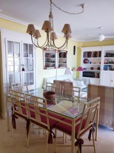 een eetkamer met een glazen tafel en stoelen bij Magnifico apartamento en primera linea de Playa in El Campello