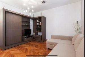 een woonkamer met een bank en een tv bij Tricolore - Sottocorno Charme Loft in Milaan