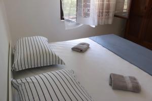 a bed with two towels sitting on top of it at Beachfront Sunshine apartment in Split
