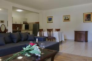 a living room with a blue couch and a table at Beachfront Sunshine apartment in Split